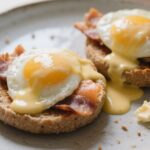Eggs Benedict with blender hollandaise and smocked salmon served on whole grain muffins in a cozy kitchen